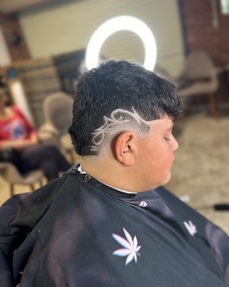 Fade with a razor-drawn leaf design on the side